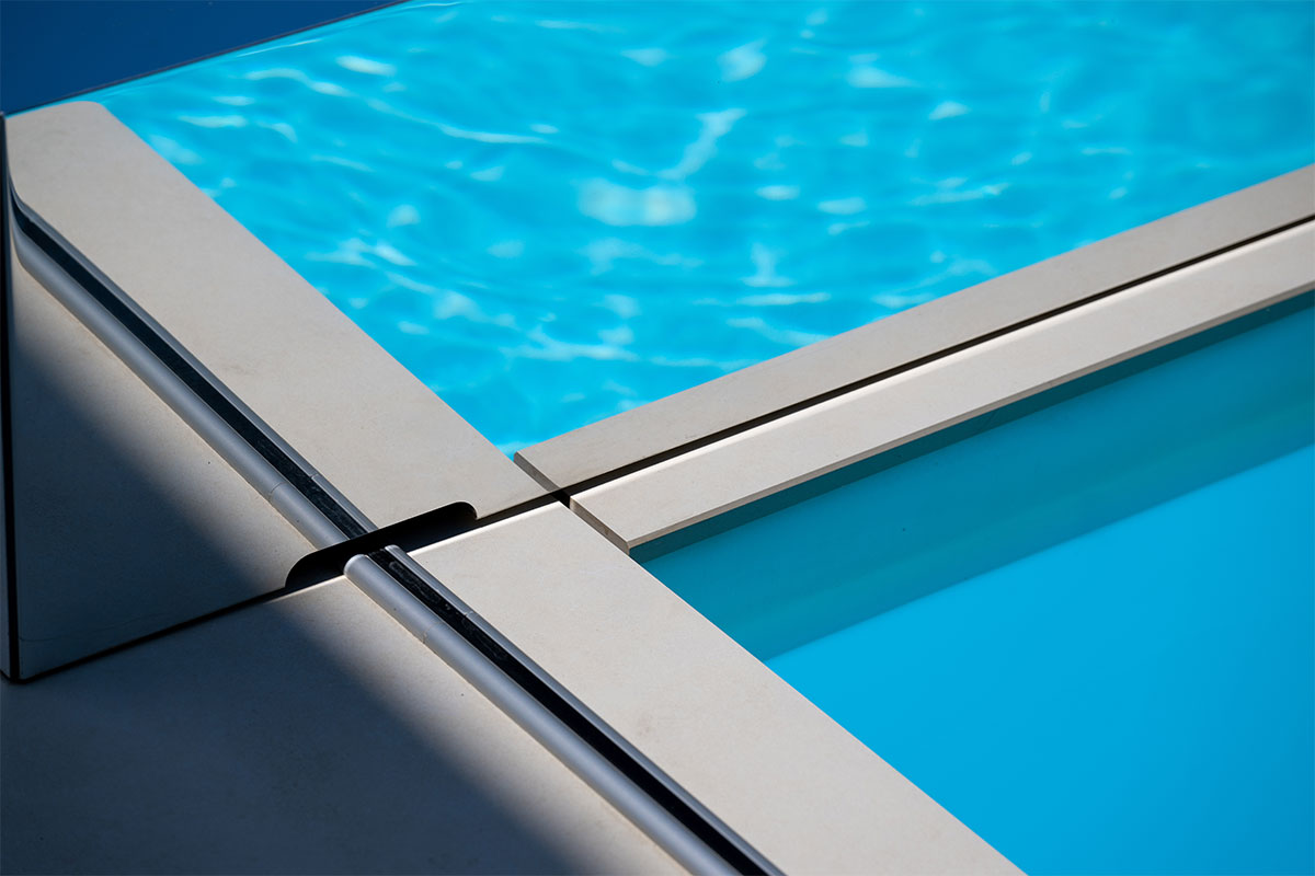 Coverseal-landscape2 Gros plan sur les rails discrets de la couverture Coverseal intégrés dans le carrelage de la terrasse, assurant une finition élégante.